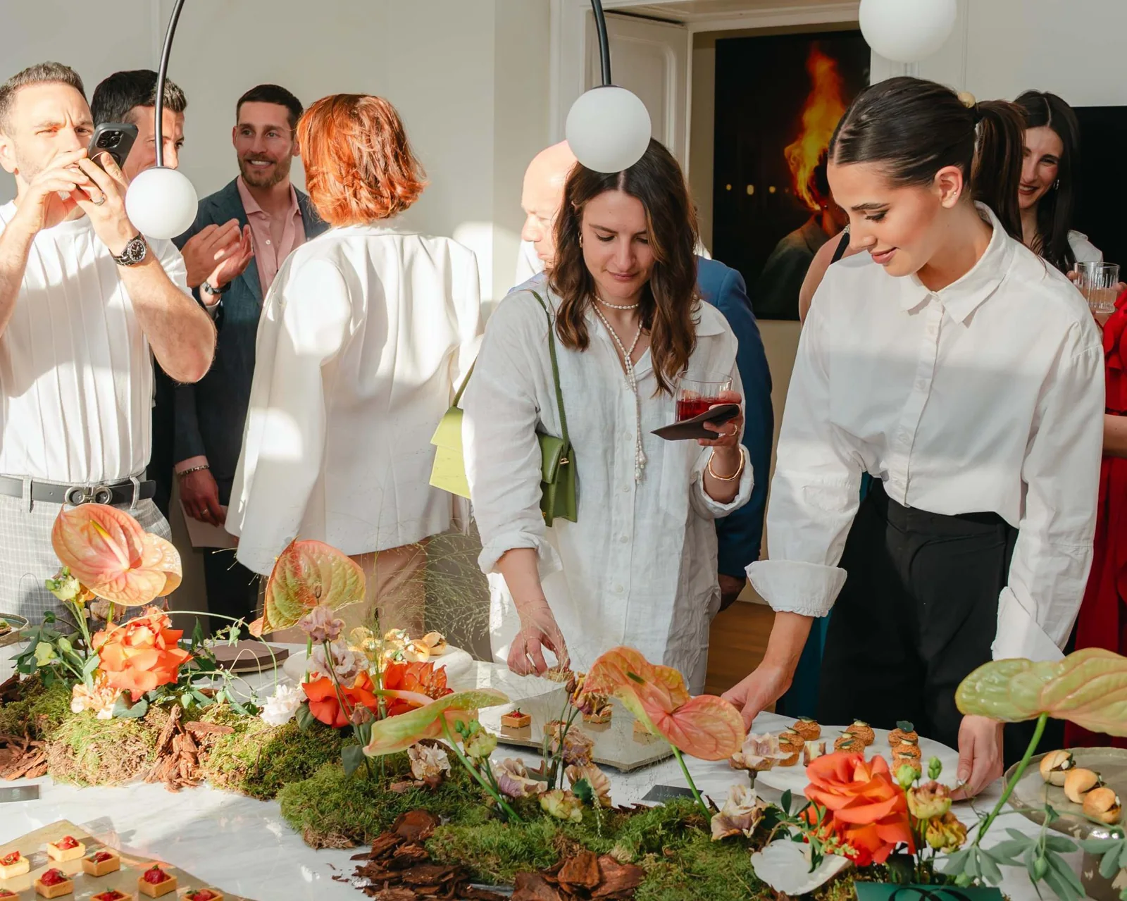 Guests gathered around flowers and a shared table at Il Salotto