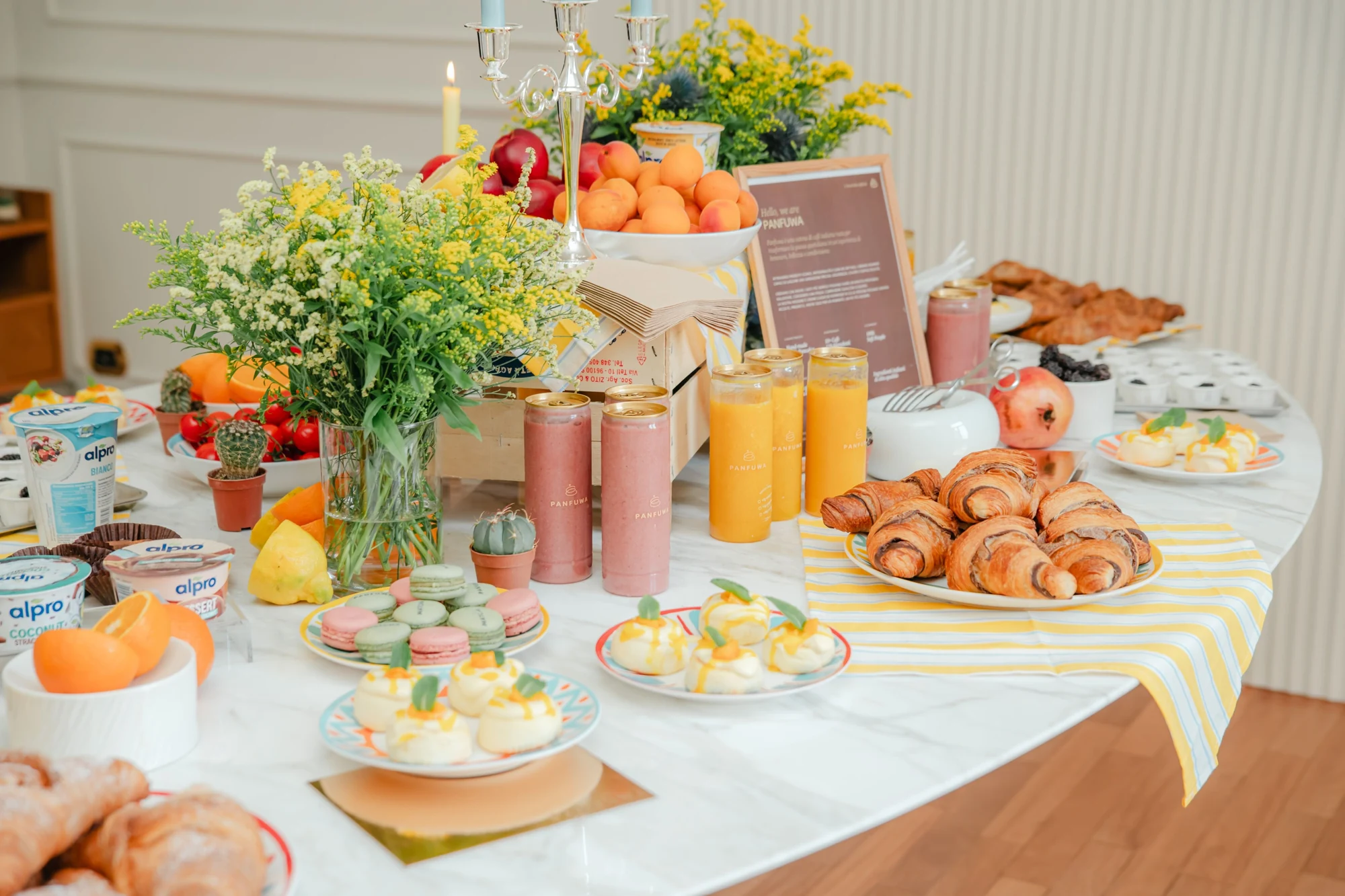 Flowers, fruit and delicate colours on a shared breakfast table